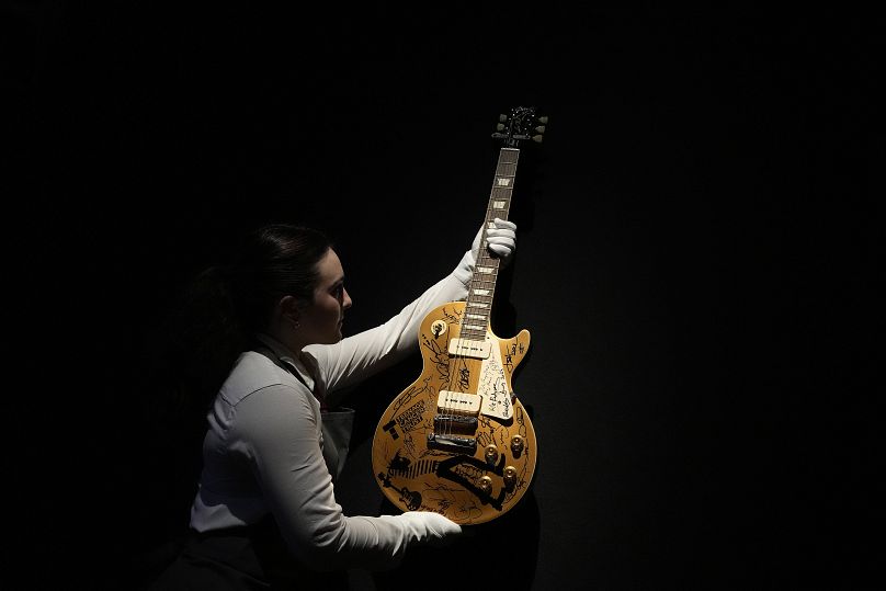 Pracownik Christie's sprawdza gitarę Gibson Les Paul „Gold Top” należącą do Marka Knopflera