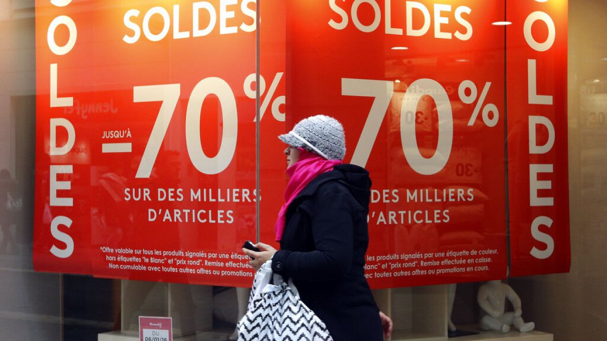 A woman walks past a store advertising for winter sales in Marseille, southern France, Thursday, Jan. 7, 2016