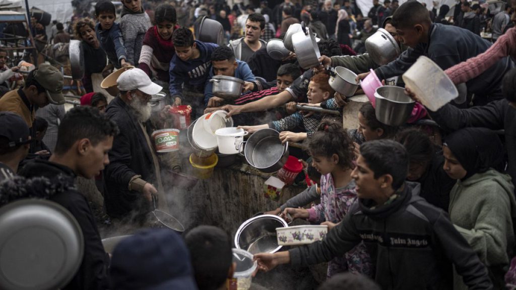 FILE - Palestinians line up for a free meal in Rafah, Gaza Strip, Thursday, Dec. 21, 2023.