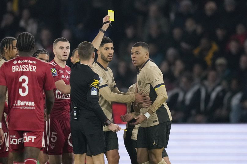 Cement Turpin pokazuje żółtą kartkę Kylianowi Mbappe z PSG podczas meczu League One pomiędzy Paris Saint-Germain a Brest, 28 stycznia 2024 r.