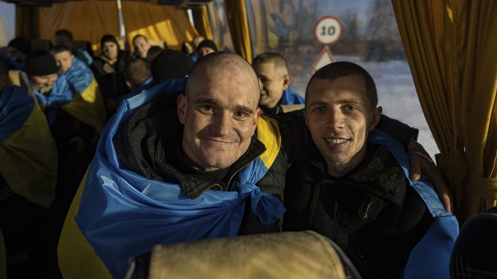 Recently swapped Ukrainian prisoners of war covered in national flags sit in a bus after a prisoner exchange on the Ukrainian Russian border, on Wednesday, Jan. 31, 2024.