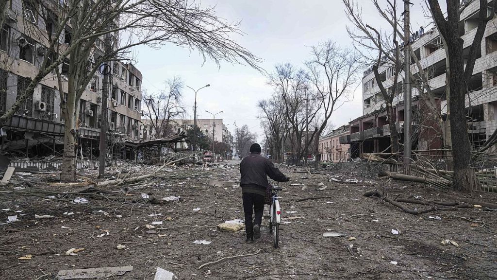 A man walks with a bicycle in a street damaged by shelling in Mariupol, Ukraine, Thursday, 10 March , 2022.