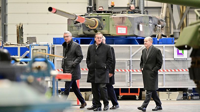 Kanclerz Niemiec Olaf Scholz (z prawej) i federalny minister obrony Boris Pistorius dokonują inspekcji hali produkcyjnej pojazdów opancerzonych grupy zbrojeniowej Rheinmetall.