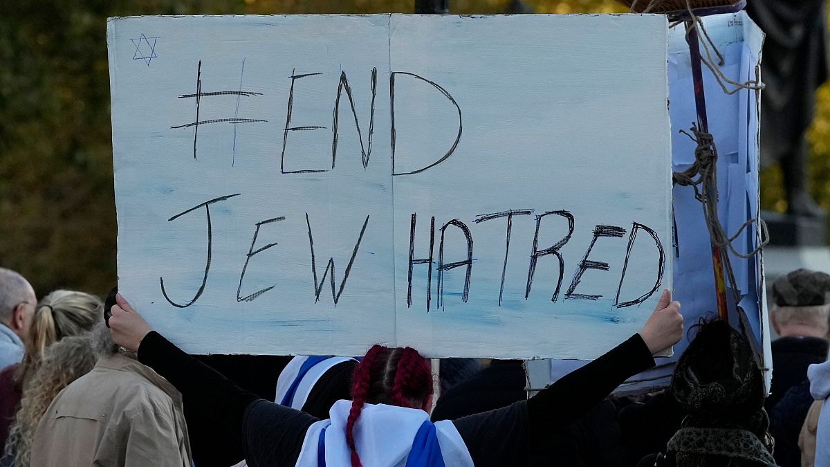 A protester holds up a placard saying