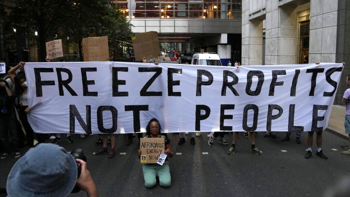 Demonstrators hold up placards as they protest outside the British energy regulator, Ofgem. London, Friday, Aug. 26, 2022.