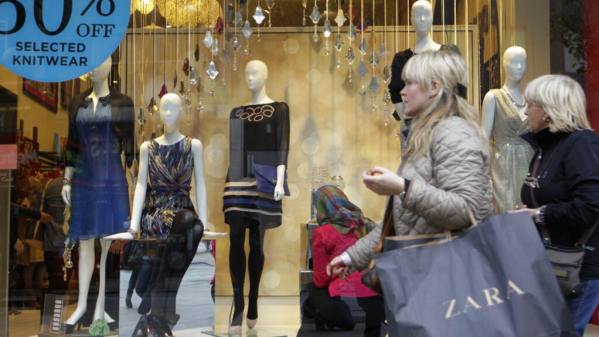 Shoppers walk by a shop in central London, Thursday, Nov. 17, 2011.