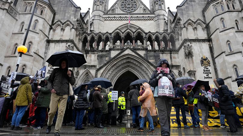 Protestujący czekają przed Królewskimi Trybunałami Sprawiedliwości w Londynie, środa, 21 lutego 2024 r.