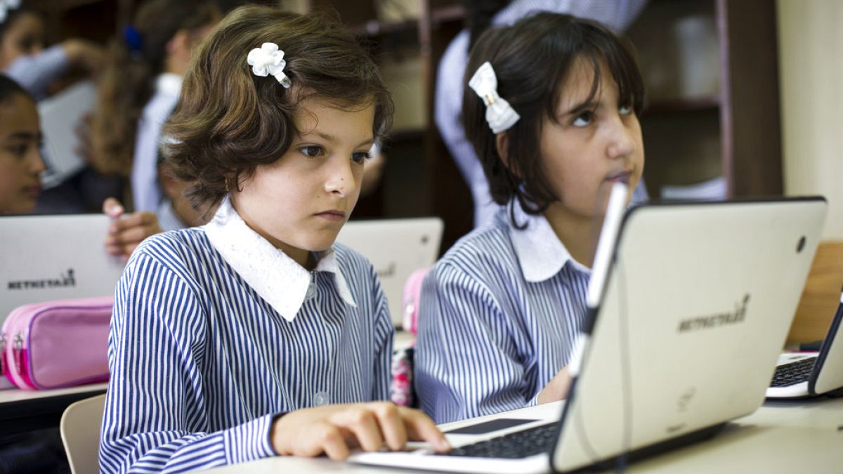 In this Saturday, Sep. 8, 2018 photo, Palestinian children use laptops at the Ziad Abu Ein School in the West Bank city of Ramallah.