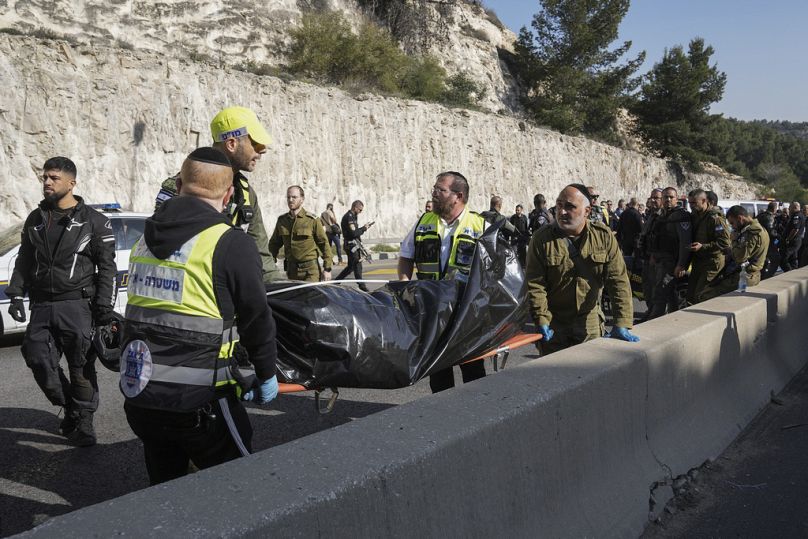 Izraelskie siły bezpieczeństwa i członkowie służb ratowniczych Zaka niosą ciało z miejsca strzelaniny w pobliżu osady Maale Adumim na Zachodnim Brzegu, czwartek, 22 lutego,