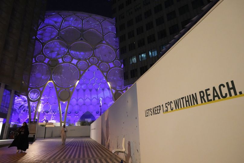 Tabliczka w pobliżu kopuły Al Wasl w Expo City głosi "miejmy 1,5 stopnia Celsjusza w zasięgu ręki" na COP28.
