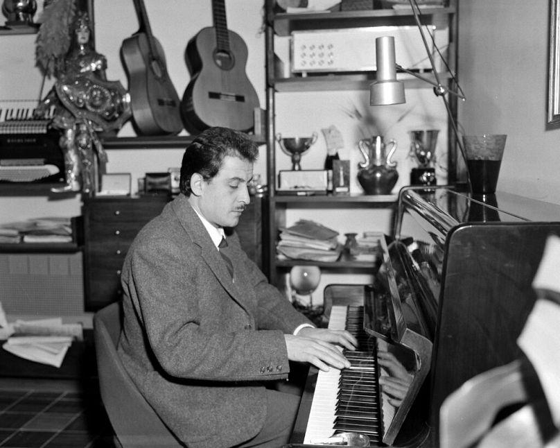 Włoski kompozytor i piosenkarz Domenico Modugno gra na pianinie w swoim domu w Rzymie, Włochy, 7 listopada 1958 r.