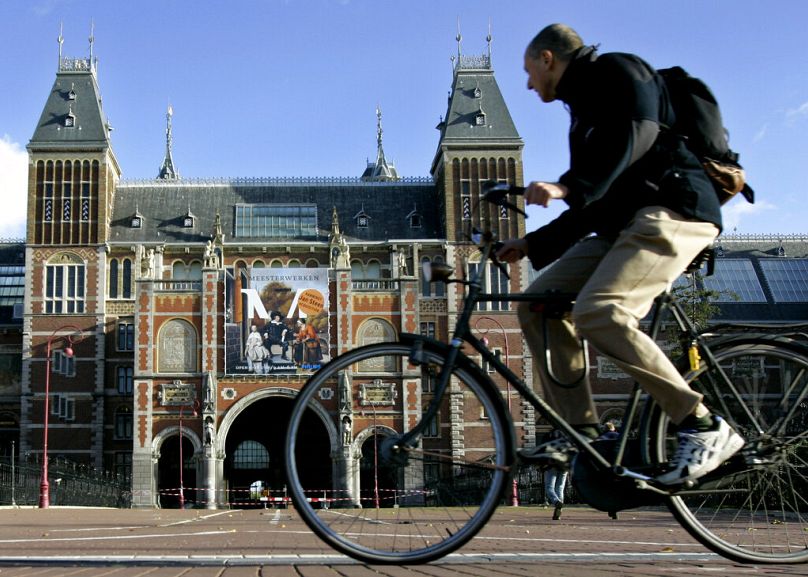 Rowerzysta mija Rijksmuseum w Amsterdamie, październik 2004