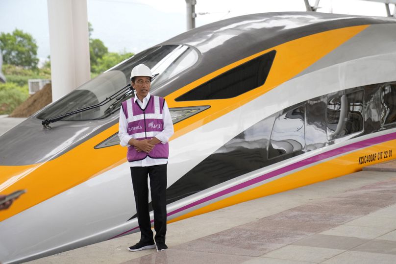 Prezydent Indonezji Joko Widodo stoi w pobliżu nowo odsłoniętej jednostki CIT podczas swojej wizyty na stacji szybkiej kolei Jakarta-Bandung w Tegalluar, październik 2022 r.
