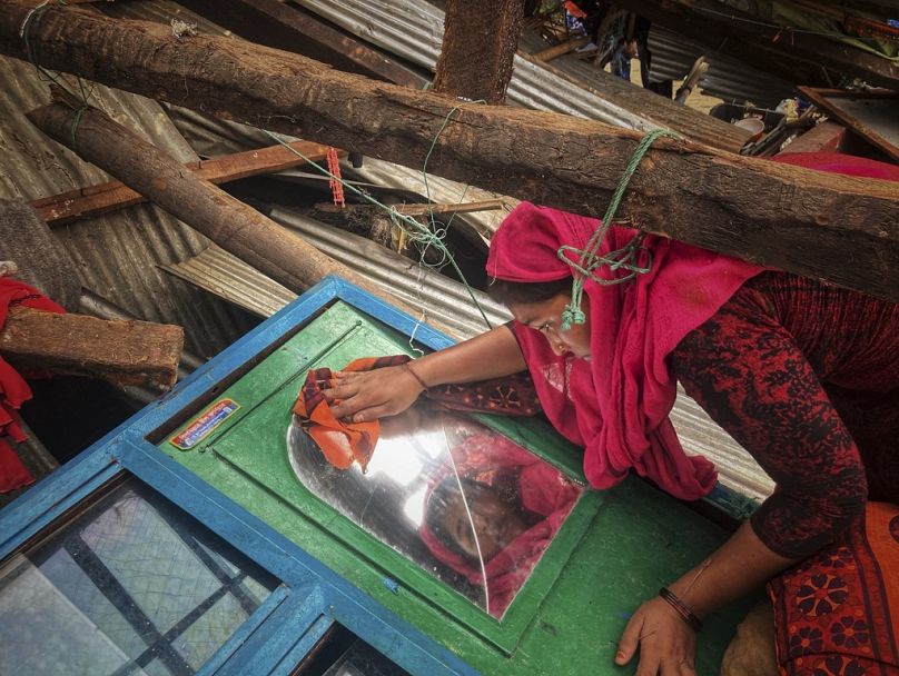 Kobieta ratuje rzeczy ze swojego domu zniszczonego przez cyklon Mocha na wyspie Saint Martin w Cox's Bazar w Bangladeszu, maj 2023 r.