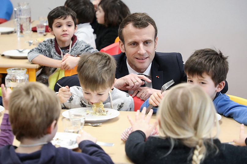 Prezydent Francji Emmanuel Macron spotyka się z uczniami podczas wizyty w szkolnej stołówce w Saint-Sozy w południowo-zachodniej Francji