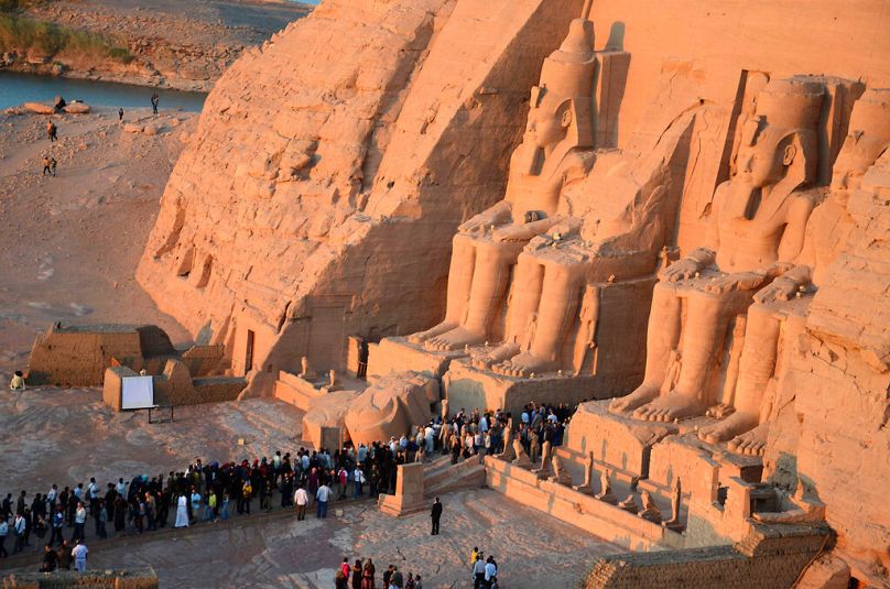 Odwiedzający gromadzą się w Wielkiej Świątyni Ramesa II w Abu Simbel w Egipcie, 870 kilometrów (540 mil) na południe od Kairu,