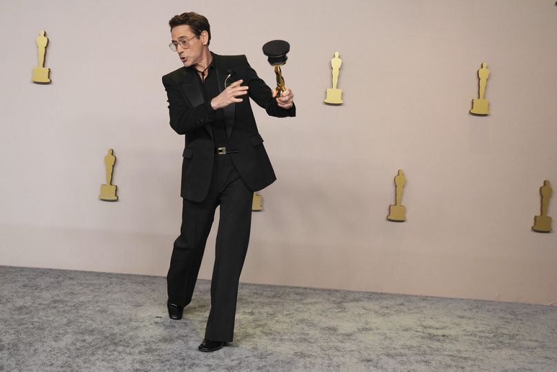 Robert Downey Jr. pozuje w sali prasowej z nagrodą za najlepszą kreację aktorską w roli drugoplanowej 