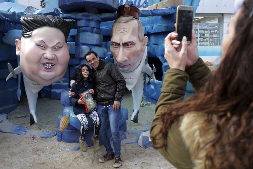 Ludzie robią zdjęcia przy posągach przywódcy Korei Północnej Kim Dzong Una (po lewej) i prezydenta Rosji Władimira Putina jako rekiny podczas obchodów karnawału w Torres Vedras.