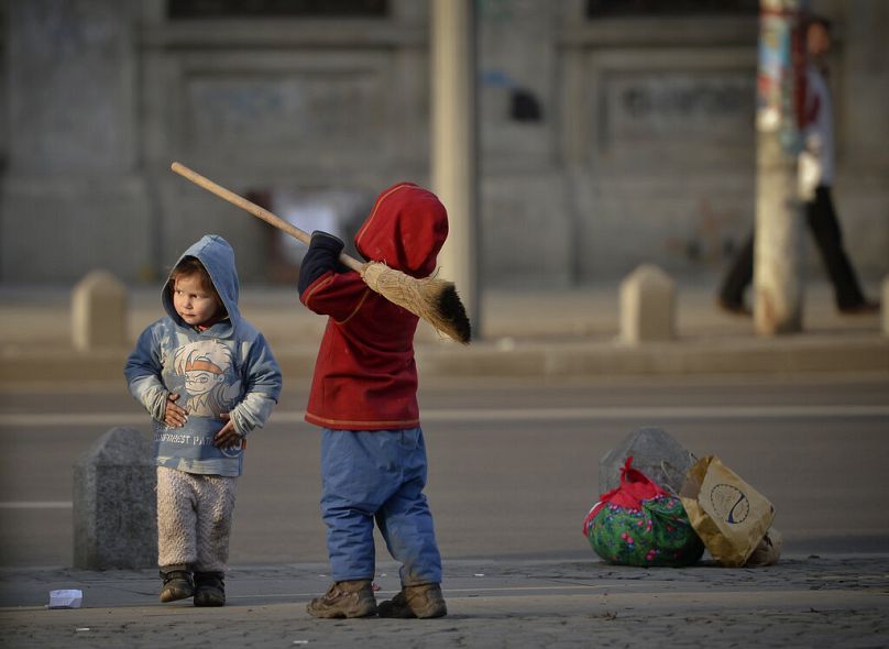 Dziecko trzyma miotłę w Bukareszcie, luty 2014 r