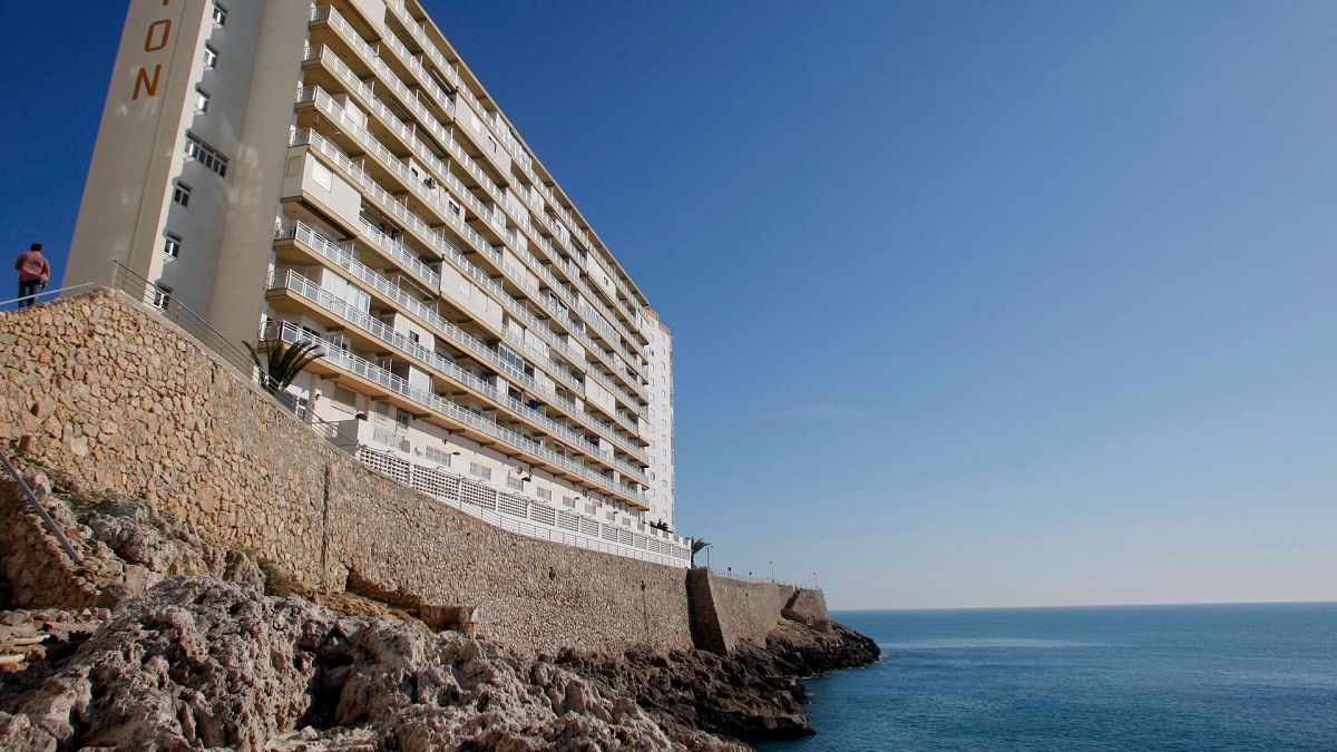 A man, left, walks towards an apartments buillding in Village of Cullera, south of Valencia, Spain, April 2008.