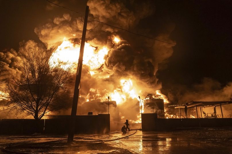 Strażacy gaszą pożar po rosyjskim ataku na dzielnicę mieszkaniową w Charkowie, marzec 2024 r