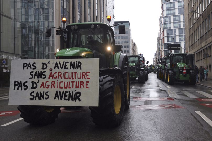 Ciągniki jadą w szyku opuszczającym miasto po proteście rolników przed spotkaniem ministrów rolnictwa UE w Brukseli, luty 2024 r.