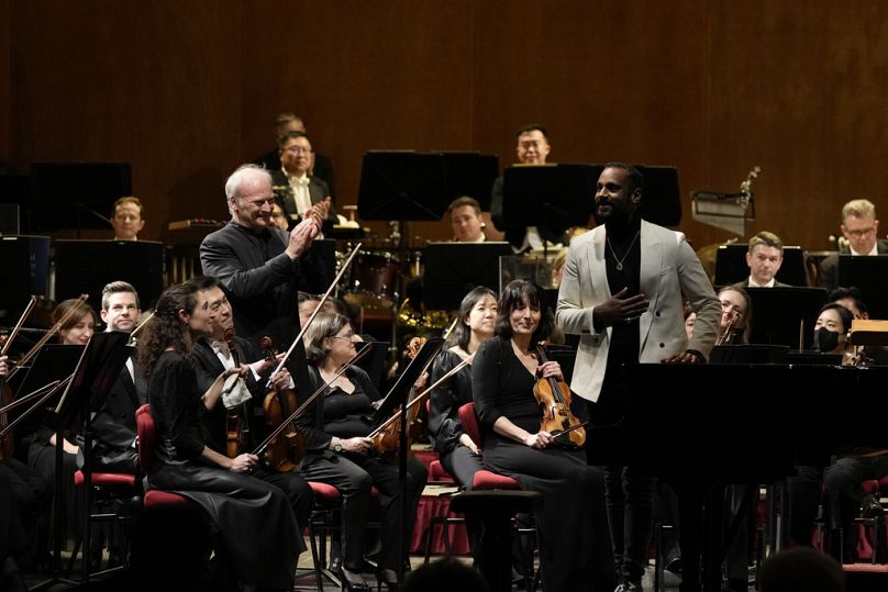 Dyrektor muzyczny Narodowej Orkiestry Symfonicznej (NSO) Gianandrea Noseda (po lewej) i kompozytor Carlos Simon uśmiechają się, przyjmując brawa podczas koncertu w mediolańskiej La Scali
