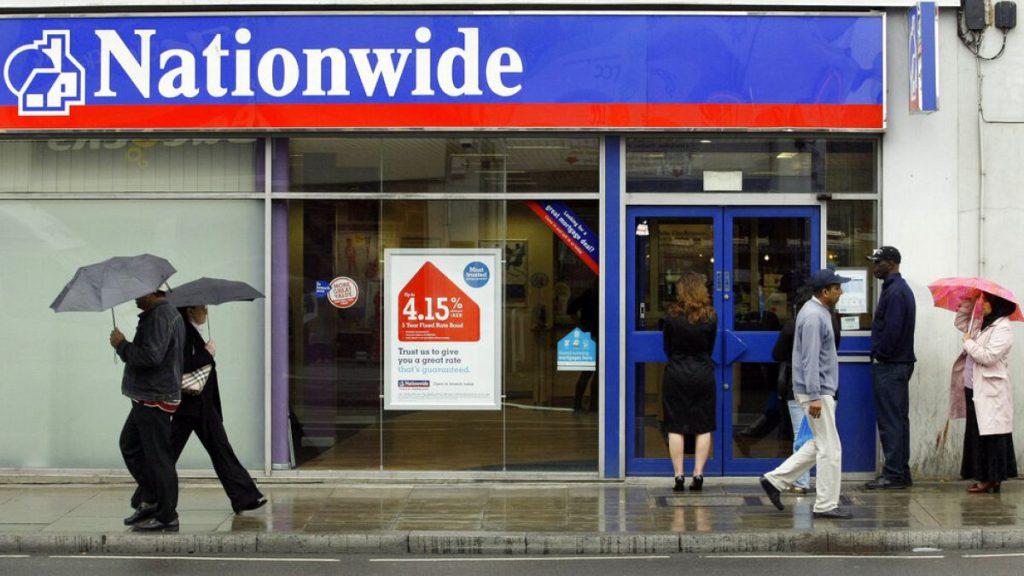 People queue up as they wait for a branch of the Nationwide Building Society to open in Tooting, south London, Wednesday May 27, 2009.