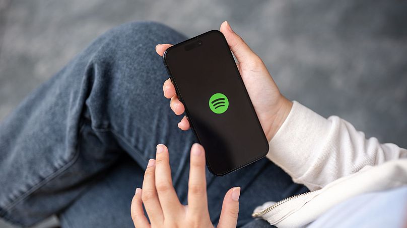 Kobieta korzystająca z aplikacji Spotify na smartfonie na świeżym powietrzu