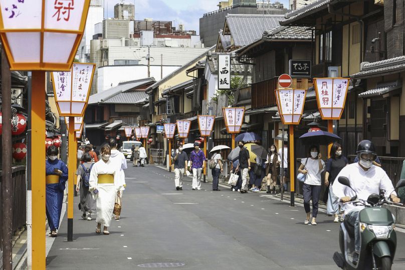 Ludzie chodzą ulicą w rejonie Gion, Kioto, zachodnia Japonia