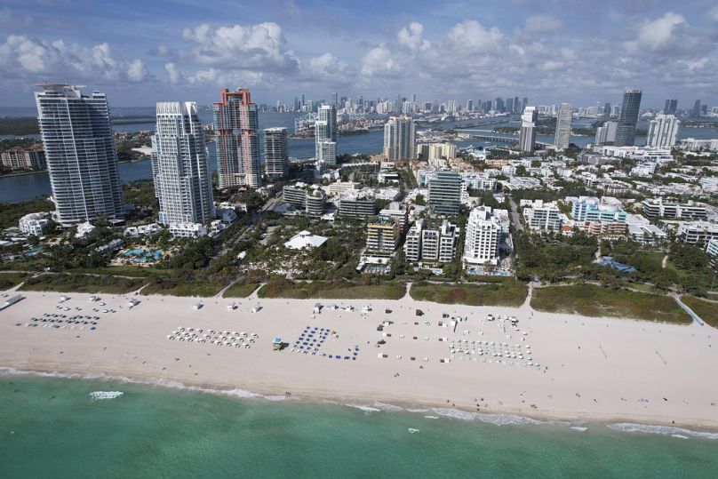 Krzesła są rozmieszczone na szerokiej piaszczystej plaży w dzielnicy South Beach w Miami Beach