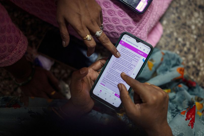 Kobiety uczą się obsługi chatbota zasilanego sztuczną inteligencją w biurze lokalnej organizacji kobiecej w Bombaju, luty 2024 r.