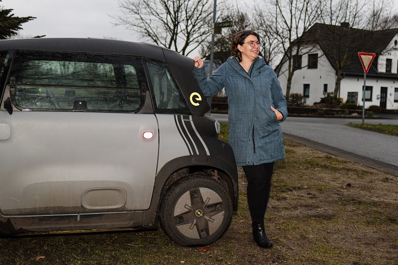 Astrid Nissen, mieszkanka wioski Sprakebuell, stoi obok samochodu elektrycznego w Sprakebuell w Niemczech.