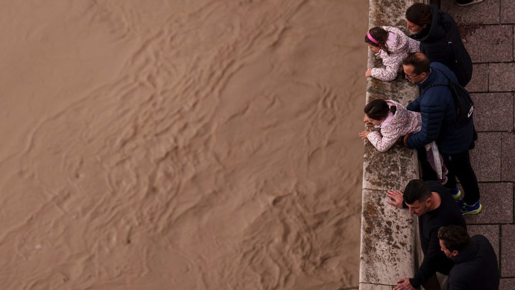 People watch the Guadalquivir river swollen after the last rains under the roman bridge in Cordoba, Southern Spain.