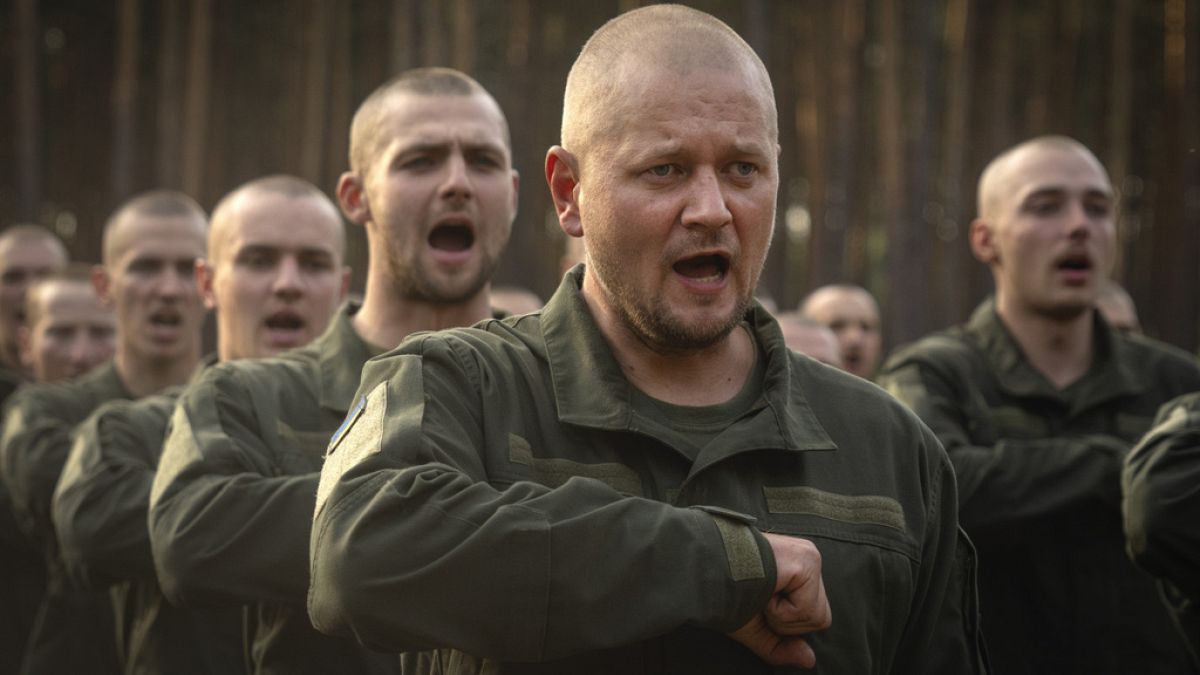 Newly recruited soldiers toss their hats as they celebrate the end of their training at a military base close to Kyiv, Ukraine, Monday, Sept. 25, 2023.