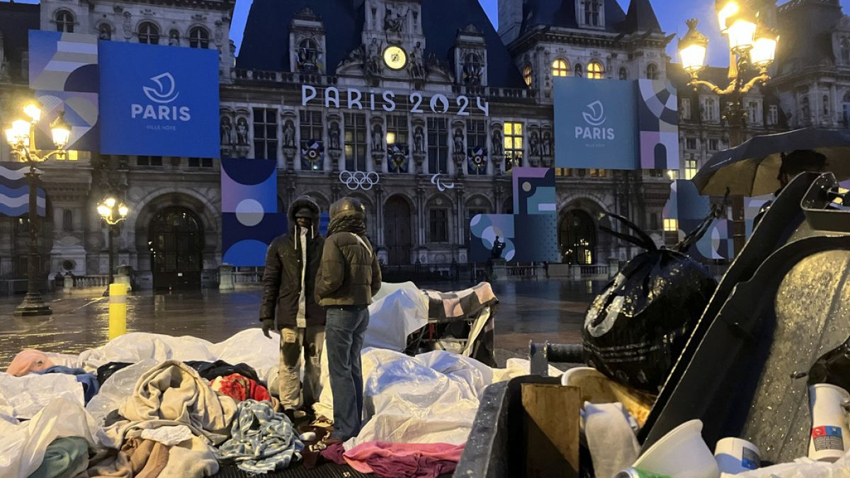 Migrants stand in front of the Paris City Hall, Wednesday, April 3, 2024.