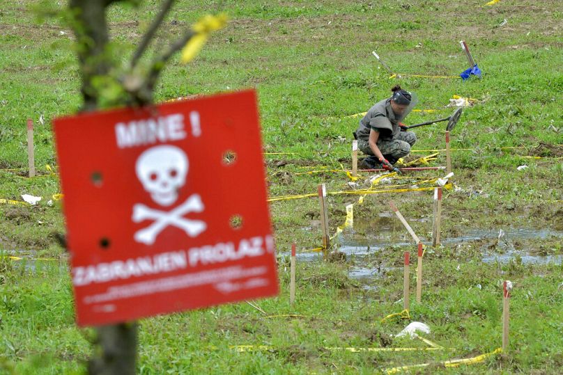 Bośniacki żołnierz szuka min na polach w pobliżu brzegów rzeki Bośni, która została zalana w pobliżu miasta Visoko, maj 2014 r.