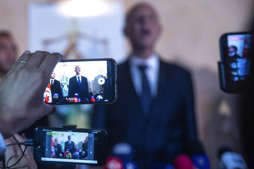 Reporterzy używają telefonów komórkowych, gdy Kais Saied z Tunezji przemawia w Tunisie, październik 2019 r.