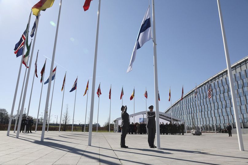 Personel wojskowy podnosi flagę Finlandii podczas ceremonii podniesienia flagi na marginesie spotkania ministrów spraw zagranicznych NATO w kwaterze głównej NATO w Brukseli, kwiecień 2023 r.