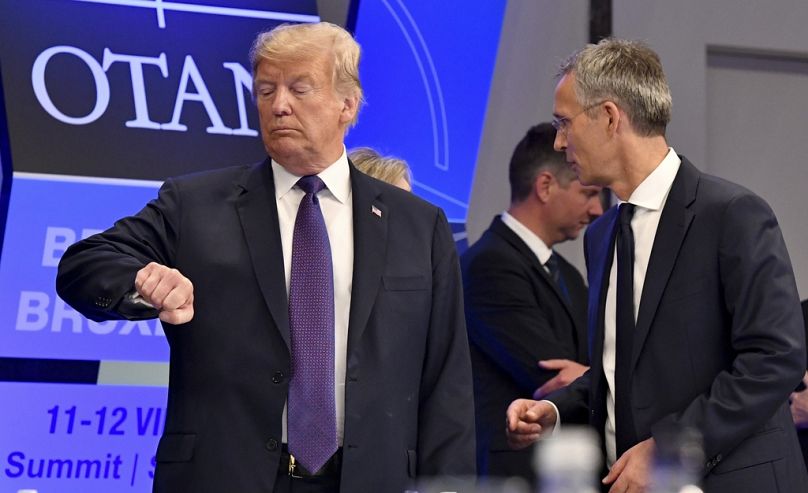 Prezydent USA Donald Trump spogląda na zegarek, gdy sekretarz generalny NATO Jens Stoltenberg stoi obok niego w Brukseli, lipiec 2018 r.