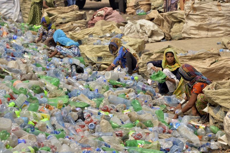 Pakistańscy robotnicy, głównie kobiety, sortują puste butelki w fabryce recyklingu tworzyw sztucznych w Hyderabad, maj 2023 r.