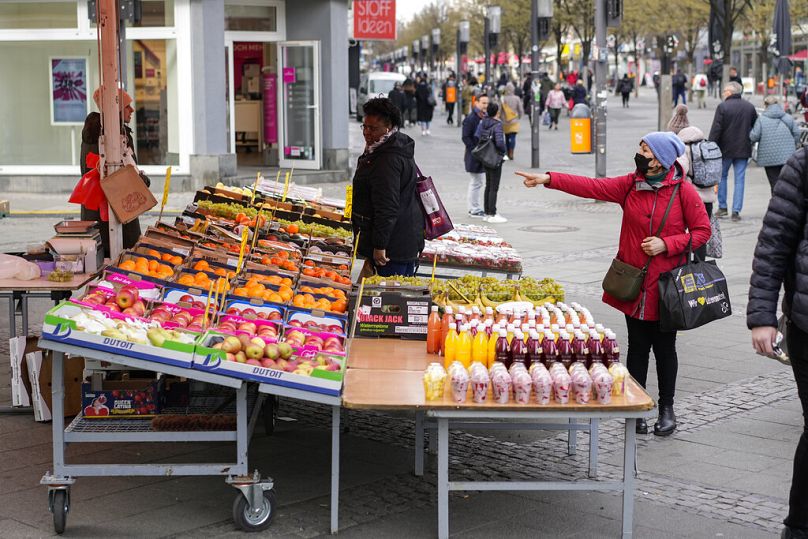 Ludzie wybierają owoce i warzywa, które chcą kupić na targu ulicznym w Berlinie, kwiecień 2022 r
