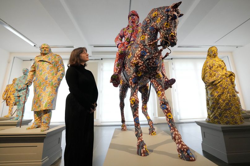Zwiedzający ogląda rzeźby wykonane z włókna szklanego i ręcznie malowane przez artystkę Yinkę Shonibare w Serpentine South w Londynie.