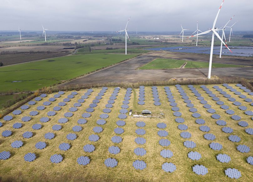 Panele słoneczne stoją na skraju farmy wiatrowej w Sprakebuell w Niemczech.