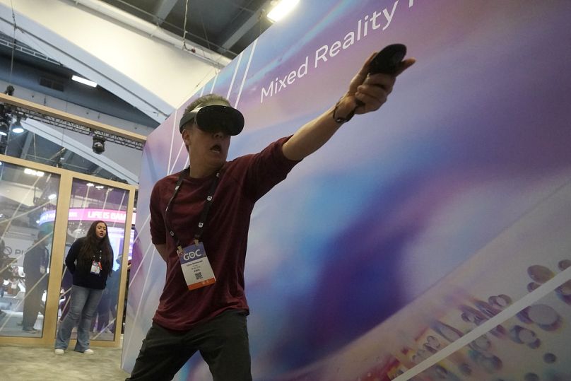 Mężczyzna gra w grę Mixed Reality Fencing Prototype podczas wizyty na stoisku Meta na konferencji Game Developers Conference 2023 w San Francisco, marzec 2023 r.