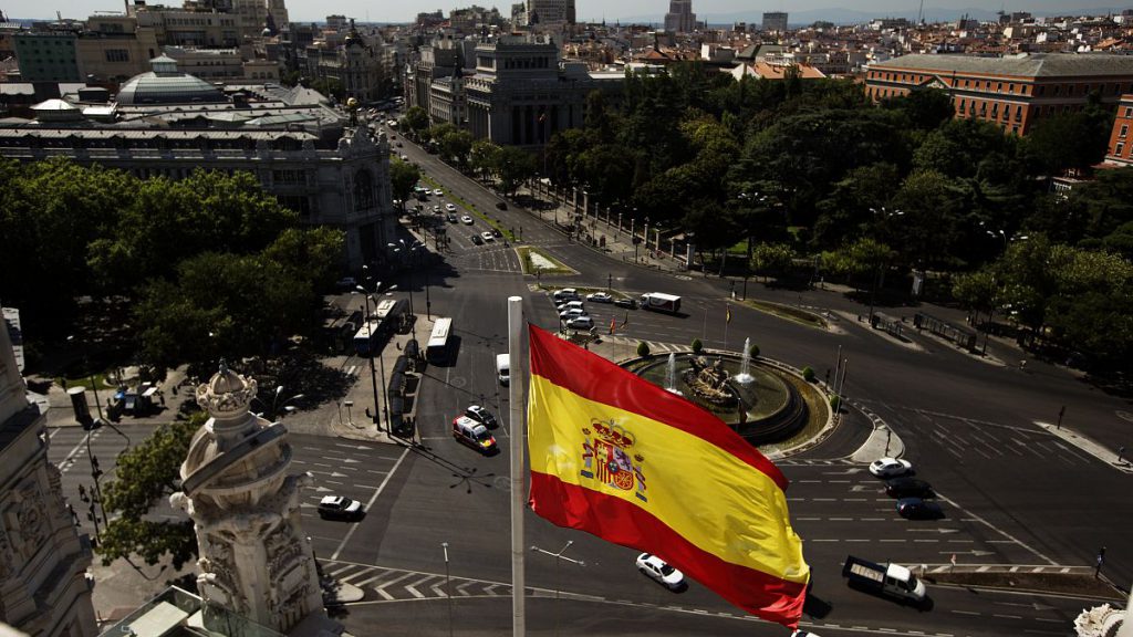 A Spanish flag waves above the Cibeles square close to Spain