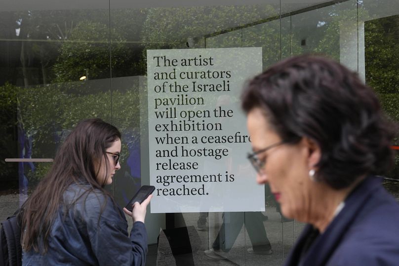Ludzie stoją przed zamkniętym izraelskim pawilonem narodowym na targach sztuki współczesnej Biennale w Wenecji, Włochy, wtorek, 16 kwietnia 2024 r.