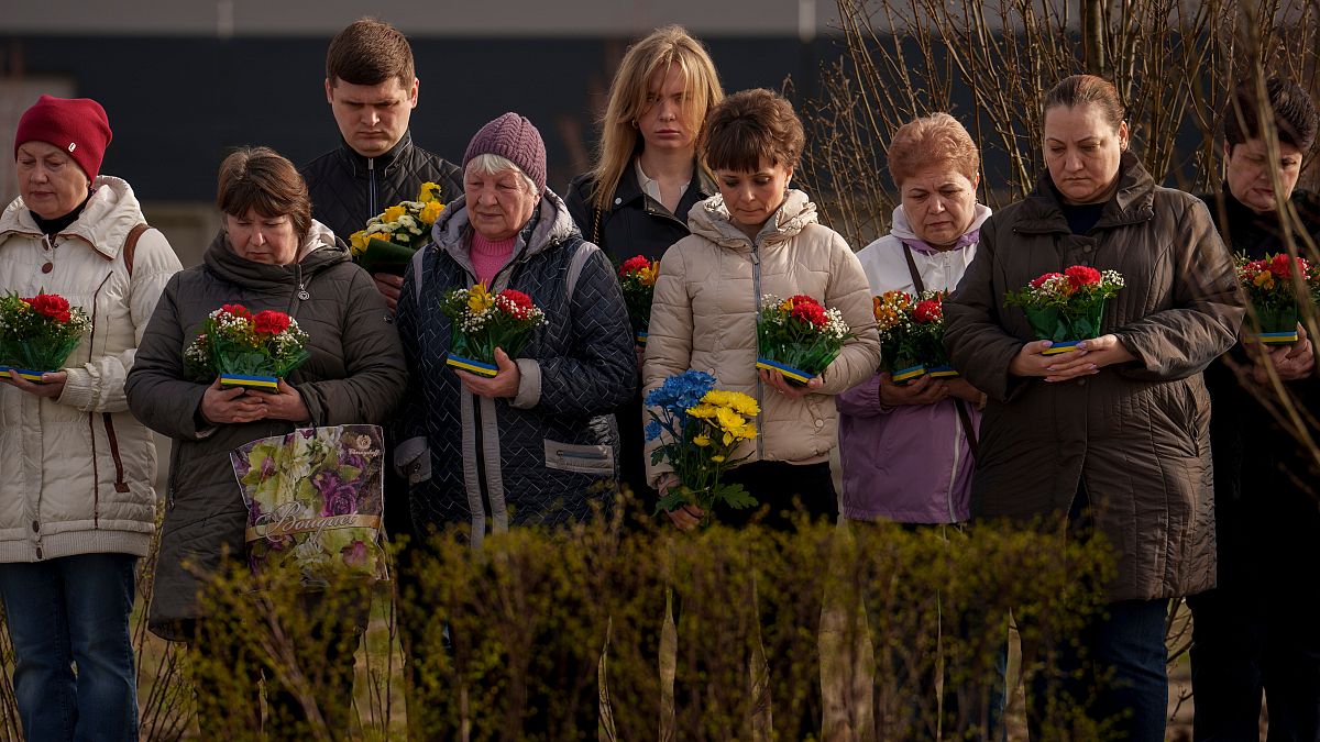 Relatives of those killed during the Russian occupation attend a commemoration of the victims at a cemetery in Bucha, Ukraine, Sunday, March 31, 2024.