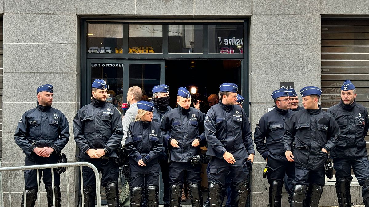 Police stand guard outside the front entrance of the event venue as the National Conservatism conference takes place in Brussels, Tuesday, April 16, 2024.