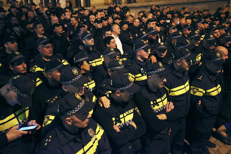 Policjanci blokują protestujących zbierających się przed budynkiem parlamentu w Tbilisi w Gruzji, wtorek, 16 kwietnia 2024 r.